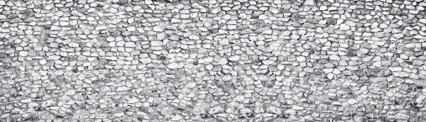 Light gray stone wall wide texture. Rough white rock panoramic vintage background