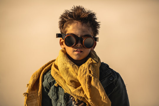 Post apocalyptic boy outdoors in desert.