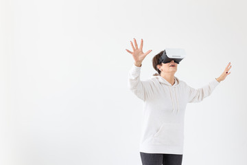 Positive pretty middle-aged woman in a white sweater watching a movie with glasses of virtual...