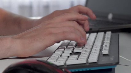Male hands typing on computer keyboard. Cropped shot of a nab working on computer, typing and clicking the mouse. Businessman working online. Freelance, technology concept