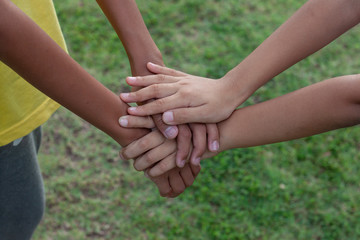 The sister held hands to encourage the brother on green lawn background.