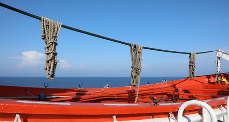 lifeboat with ropes in a cruise ship off the ocean