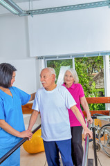 Group of elderly people rehabilitating indoor in a gym with asian trainer