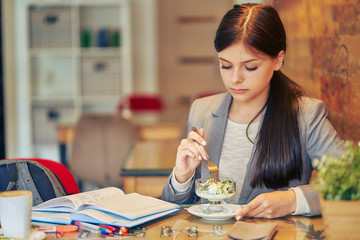 schoolgirl in a cafe is preparing for lessons