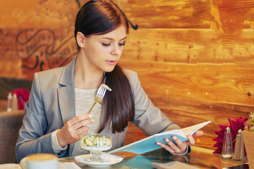schoolgirl in the cafeteria reading a textbook