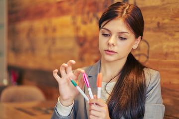 student girl in cafe chooses pen color