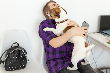 Animal, pet and people concept - Attractive cheerful man in plaid shirt holds favourite pet