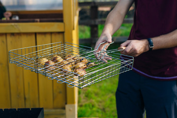 man carries a grill grill with potatoes