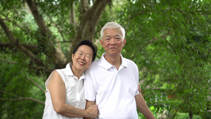 Asian senior couple smiling happy green tree background