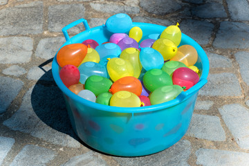 Blue plastic tub filled with water bombs © photology1971