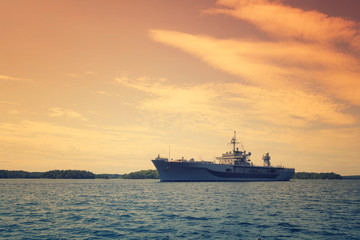 Grey modern warship sailing in still water, marine military boat on the sea.