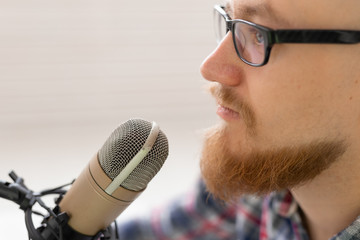 Radio, DJ, blogging and people concept - Close-up of man sitting in front of microphone, host at radio