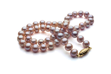 A single strand necklace of Purple pearls with a gold clasp are crossed over itself. Shown on a white background with shadow.