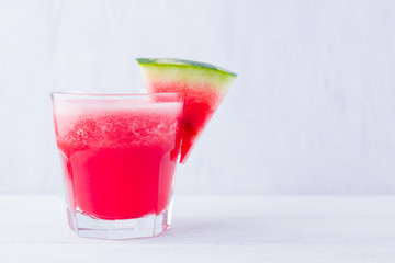 Watermelon drink in glasses with slices of watermelon. Watermelon smoothies on white background. Summer healthy drink for vegetarian. Copy space