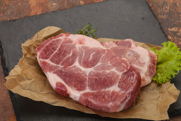 Raw pork steak over wooden board