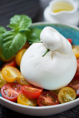 Burrata cheese with cherry tomatoes, selective focus, close-up, vertical shot