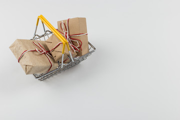 Gifts in a small shopping basket on a white background, concept, copy space.