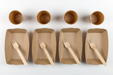 Ecological paper utensils, naturally decomposed materials. Plates, cups and wooden forks, a natural set for a picnic.