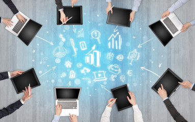 Group of people with devices in hands making reports together on laptop, tablet, notebook