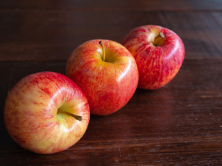 Three apple fruit, on a wooden background.