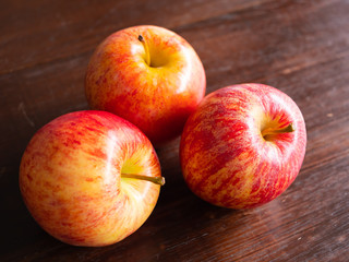 Three apple fruit, on a wooden background.