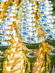 Gold cups are on the table before the presentation.