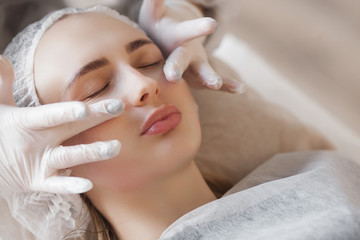 master making a cosmetic procedure for her client. skin care treatment. woman making a face care procedure.