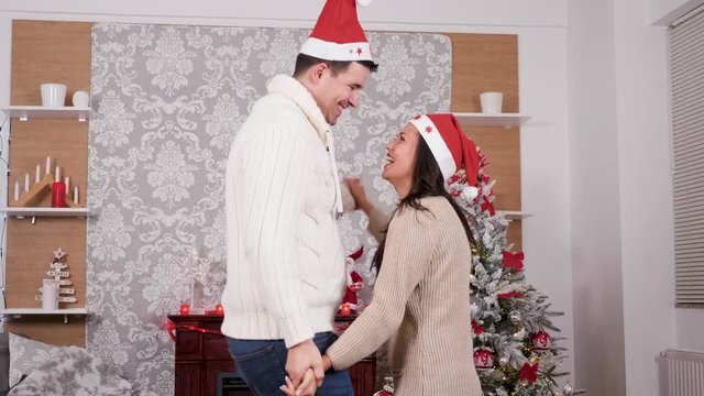 Lovely couple dancing and having fun in Christmas eve, slow motion close up shot