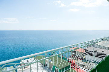view of the Black Sea and various buildings from the balcony with railings at an inexpensive resort