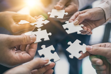 A group of business people assembling jigsaw puzzle.