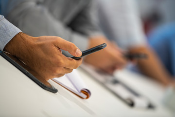 Man hand taking notes, Writting and scrolling phone in a meeting at work