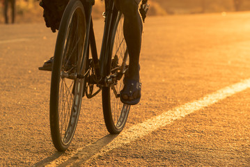 Closeup of bicycle wheels/tires on a tarmac road in Mozambique at sunrise. African/Mozambican...