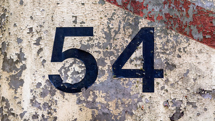 metal background texture with chipped white and red paint and the number 54