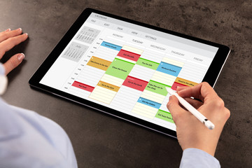 Business woman schedule her weekly program on tablet