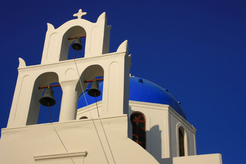 Biała dzwonnica i kopuła kościoła w Oia, Santorini (Thira) w Grecji