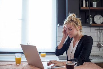 Obraz premium Young woman having headache while working on laptop.