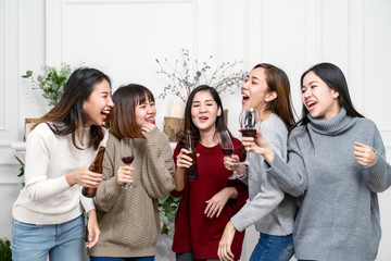 Young attractive woman asian group of friend drinking, laughing and fun with happy in gathering reunion meeting, New year party and Christmas party at home. Funny group fun and enjoy in leisure time.