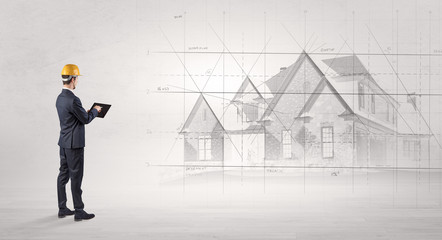 Architect standing and watching an imagined house plan