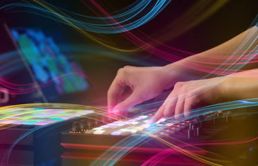 Hand mixing music on midi controller with colorful vibe concept