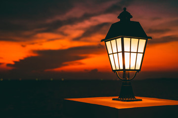 Public classic lights lamp at beach side with landscape view of sunset sky at behinds