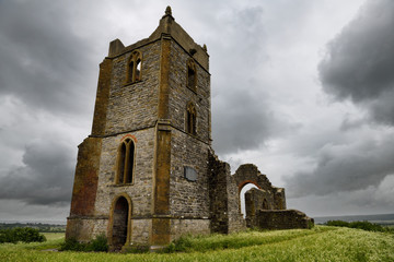 Ruins of St Michael's Church on top of Burrow Mump overlooking Southlake Moor in Burrow Bridge England under cloudy sky