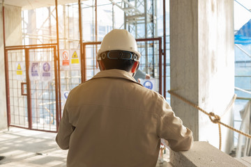 Fototapeta premium Construction site concept., Site engineer review blueprint layout before inspection construction site. ,Background sun flare.