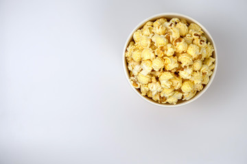 Tasty popcorn with bucket on white background., top view.