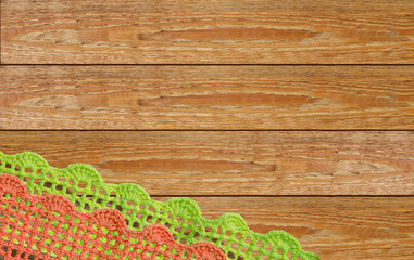 Lace knitted by hand on a wooden surface.