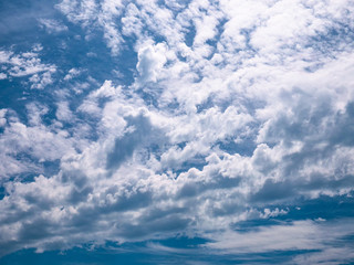 Fototapeta na wymiar Background of clouds making shapes on a sunny blue day