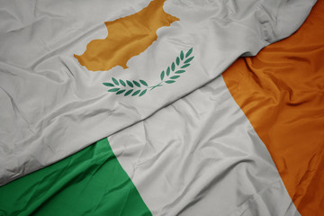 waving colorful flag of ireland and national flag of cyprus.
