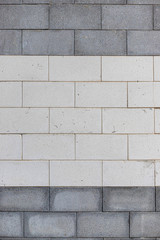 Fototapeta premium Close up outside view of a gray and white wall made of rectangular stone bricks