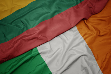 waving colorful flag of ireland and national flag of lithuania.