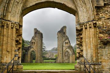 View of Abbey House and ruins of the Great Church from Lady Chapel at Glastonbury Abbey monastery in pouring rain in Glastonbury England