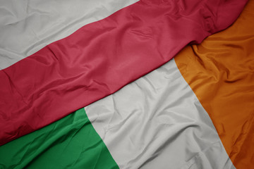 Fototapeta premium waving colorful flag of ireland and national flag of poland.